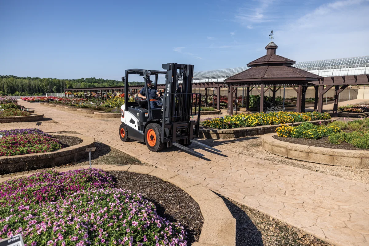 Bobcat forklift working outdoors on unimproved ground